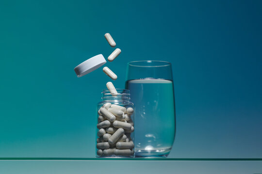 transparent glass bottle filled with white medical pills