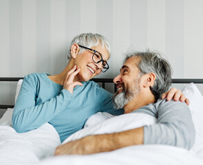 couple senior bed woman man home wife husband love together elderly caucasian adult happy retirement mature male old bedroom smiling resting retired aged relaxation leisure lying relationship - obrazy, fototapety, plakaty