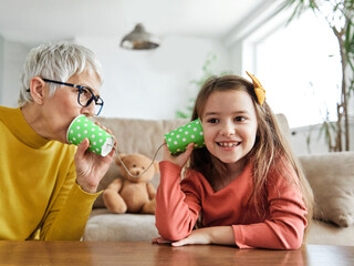 grandchild family child grandparent grandmother game playing granddaughter phone toy communication...