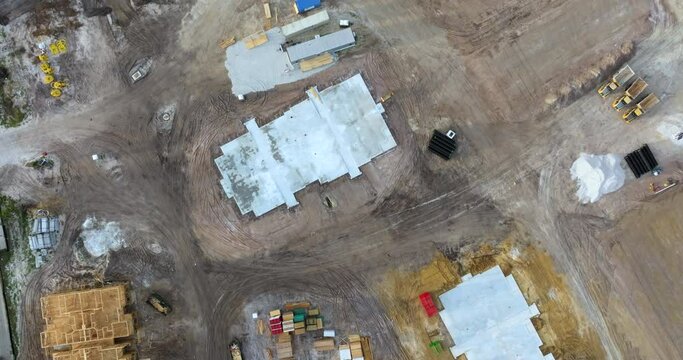 Beginning of construction works on prepared ground. Large building site with scattered equipment in American rural area. Development of residential housing in US suburbs. Real estate market in USA