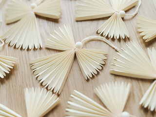 Angel decoration made in origami technique placed on wooden surface