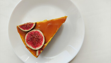 A piece of pumpkin cheesecake with homemade caramel and fresh figs