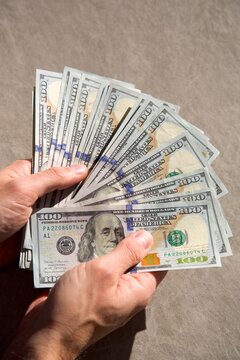 Counting a pile of hundred dollar bills closeup