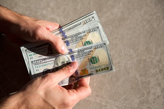 Counting a pile of hundred dollar bills closeup