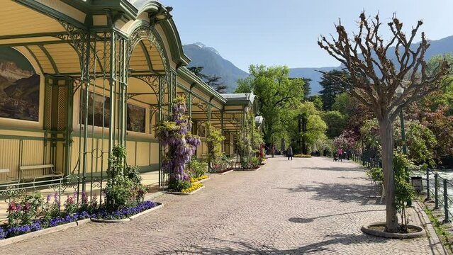 Frühlingszauber in der Wandelhalle: Erleben Sie die mediterrane Atmosphäre und das lebhafte Treiben in der Fußgängerzone von Meran, Südtirol
