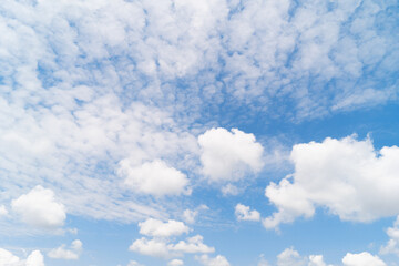 Scattered cumulus clouds against a blue sky, sunlight filtering through. Climate changes concept.