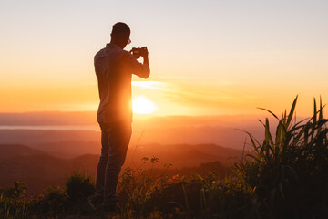 Man taking photo at sunset