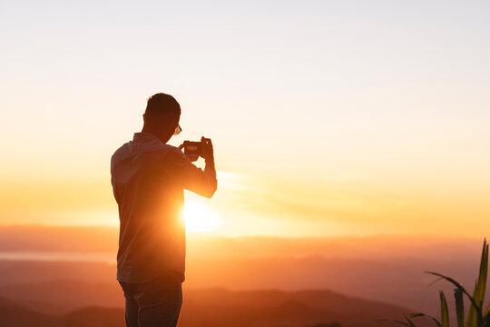 Man taking photos at sunset