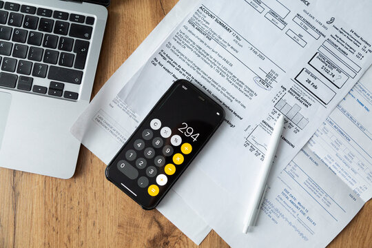 Smartphone calculator with documents on table