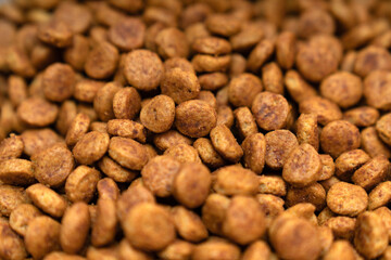 Food for animals background. Dry cat and dog food texture, pattern. Pet meal background close up. Dry food for pet dogs and cats. Dried pet food top view. Granules of good nutrition for dogs and cats.