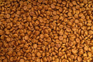 Food for animals background. Dry cat and dog food texture, pattern. Pet meal background close up. Dry food for pet dogs and cats. Dried pet food top view. Granules of good nutrition for dogs and cats.