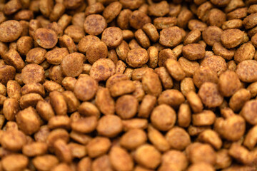 Food for animals background. Dry cat and dog food texture, pattern. Pet meal background close up. Dry food for pet dogs and cats. Dried pet food top view. Granules of good nutrition for dogs and cats.