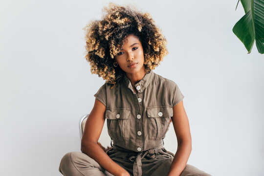 Confident young black woman with curly afro hair posing