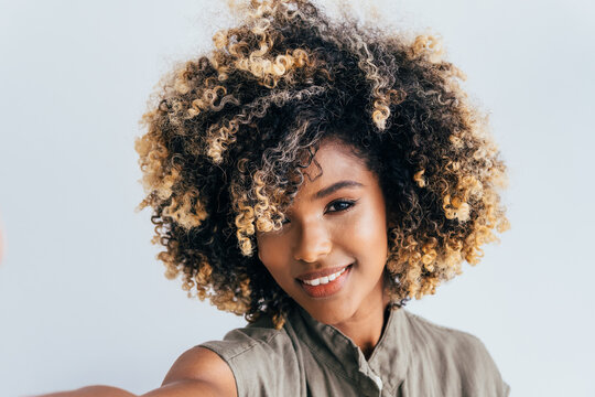 Vibrant afro young woman with curly hair smiling