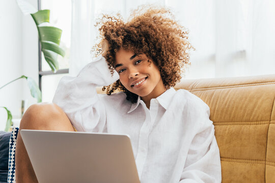 Casual latin american woman working on laptop at home