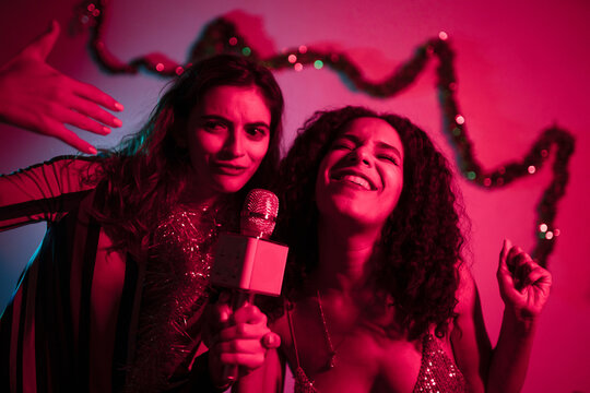 Women singing at karaoke party
