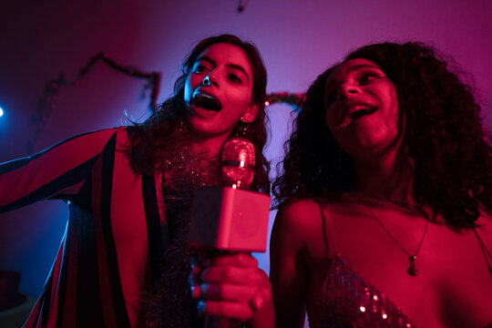 Women singing at karaoke party