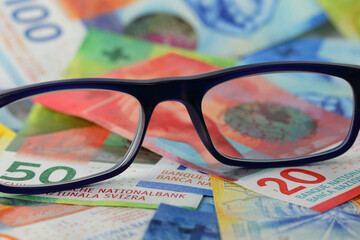 Eyeglasses and Swiss franc banknotes