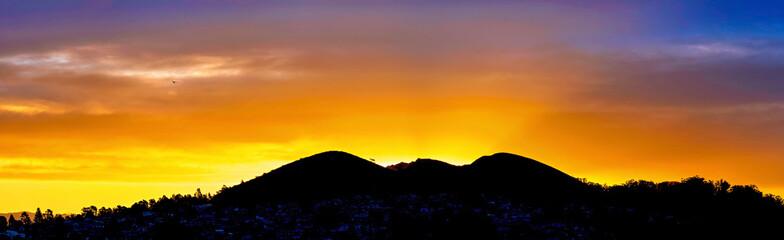 Panorama of sunset, sunrise over silhouetted Mountain, horizon, 