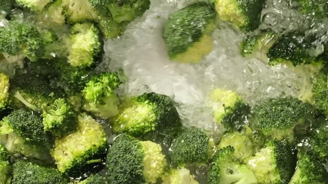 A surge of pristine water washes over succulent broccoli, infusing the frame with a sense of renewal and freshness. It's a visual ode to the purity and essential hydration of vegetables for peak