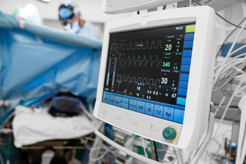 Monitor screen with vital sign and ECG data of patient during surgery inside operating room in...