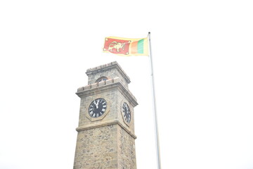 Galle Clock Tower and the Sri Lankan national flag that waving in Galle Fort, Galle, Sri Lanka.