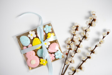 A box of Easter cookies of pastel colors and blooming branches