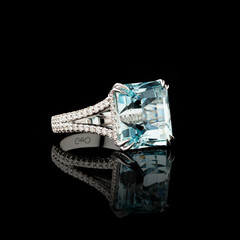 Beautiful white gold ring with diamonds and aquamarine on a black background