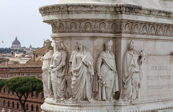 Marble group representing an allegory of the noble cities, at the Altare della Patria in Piazza Venezia in Rome, in the background the dome of St. Peter's.