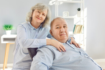 Portrait of a happy senior family couple wife and husband sitting in the living room at home and...