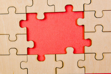 Close up of wooden puzzle pieces on red background with copy space