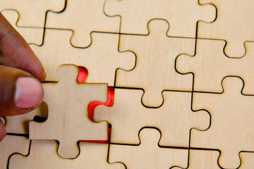 Close up of hand connecting jigsaw puzzle pieces Business concept