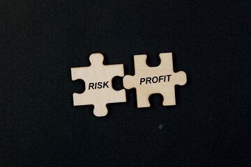 Jigsaw puzzle pieces with word Risk Profit isolated on black background