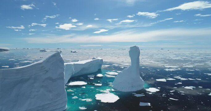 Iceberg melt at turquoise ocean bay in sunny day. Crashed glacier drifts in ocean, floating ice floes. Ecology, melting ice, climate change global warming. Antarctica majestic landscape drone view