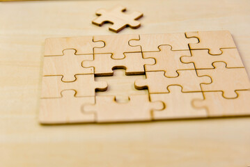 Close up of wooden jigsaw puzzle pieces on wooden table background