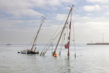Picture of a sunken sailing yacht with masts sticking out of the water near Walvis Bay in Namibia