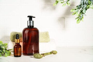 Beauty products in the bathroom on white background. Soap, serum bottle, jade roller. Skin care.