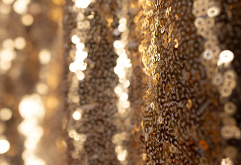 Fabric with glitter texture and vertical waves. Wavy gold sequin curtain Abstract background