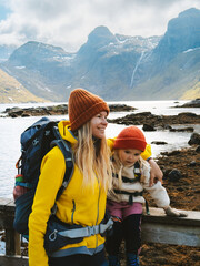 Mother and child traveling in Lofoten islands family vacations in Norway adventure healthy lifestyle outdoor, parent and kid backpacking together