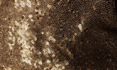 Golden wavy fabric for wallpaper.Textile texture with gold and bronze sequins.Metallic glitter and...