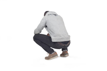 side,back view of man squatting and looking down on white background - 783352444