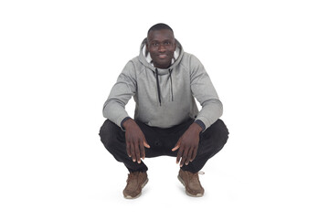 front view of man squatting and looking at camera on white background - 783352481