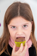 Niña come un muffin, retrato de cerca