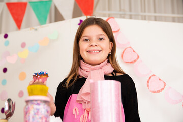 Pequeña niña rubia sonriente en la cocina