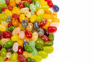Assorted candy beans of various colors on a white background