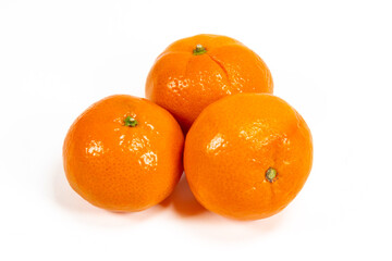Closeup of three ripe mandarin oranges isolated on white background