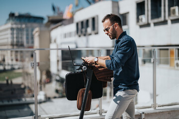 Confident male professional uses laptop on a terrace with urban backdrop, embodying mobile office...