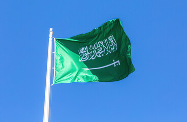 National flag of Saudi Arabia waving in the wind against a blue sky