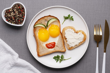 Valentine's Day breakfast with egg heart shaped and toast bread on grey background. Top view. Copy space