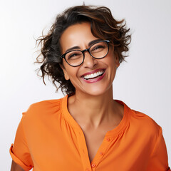Obraz premium A woman with glasses is smiling and wearing an orange shirt. She has a bright and happy expression on her face